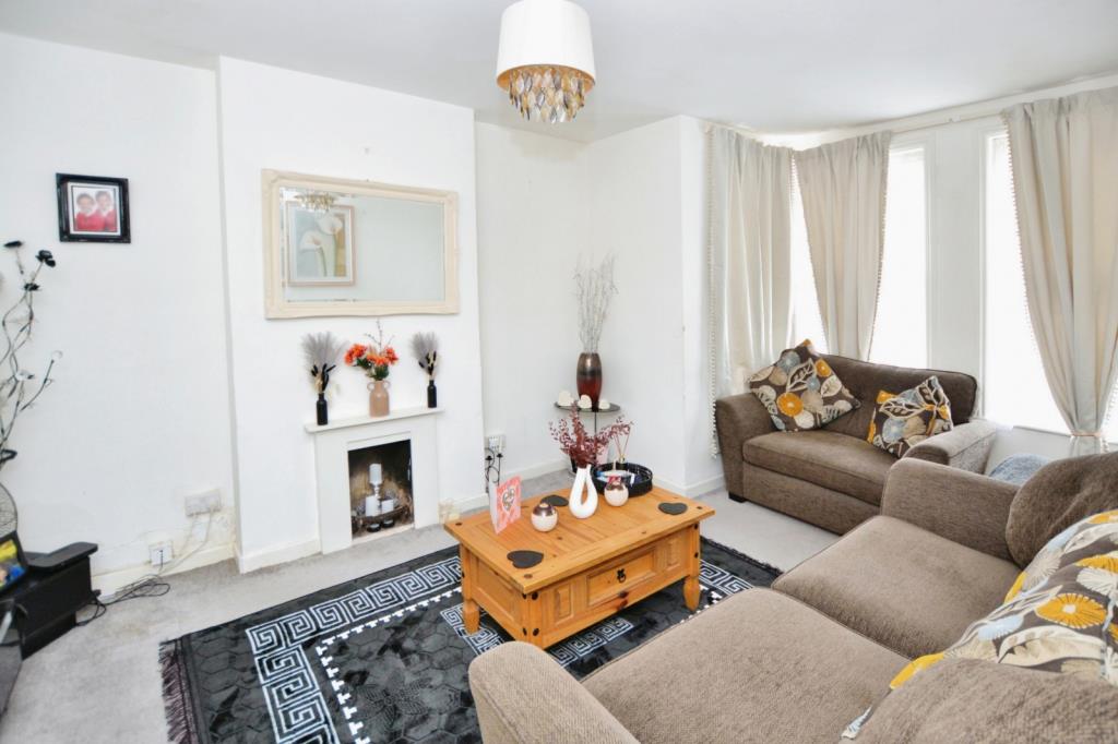 Lot: 71 - FREEHOLD DETACHED BUILDING ARRANGED AS TWO FLATS CURRENTLY LET - Flat 1 Living room with bay window and fireplace